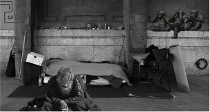 Un homme sans-abri assis seul avec son chien, entouré de ses affaires dans un abri improvisé, symbolisant la solitude et la précarité de la vie dans la rue. Un homme sans-abri assis seul avec son chien, entouré de ses affaires dans un abri improvisé, symbolisant la solitude et la précarité de la vie dans la rue.